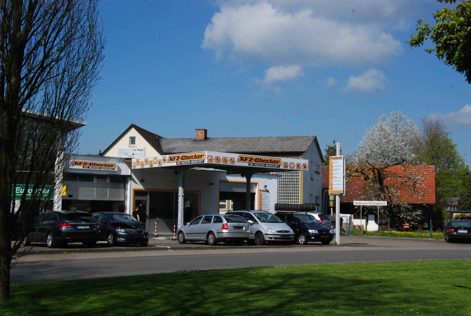 Die Werkstatt KFZ-Checker in Schorndorf von der Straße aus gesehen, Autos vor dem Tor
